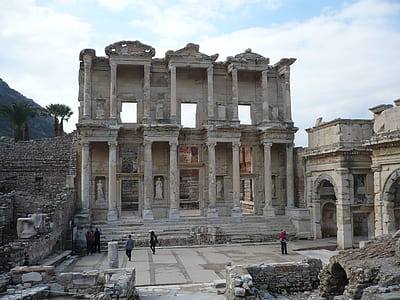 five people standing and walking beside abandoned building during daytime thumbnail