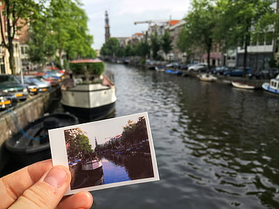 person holding photo in front of body of water thumbnail