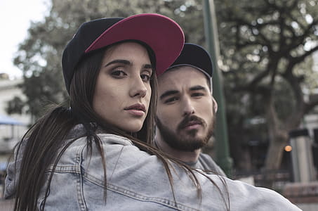 Woman in Blue Denim Jacket Near Man in Black Cap thumbnail