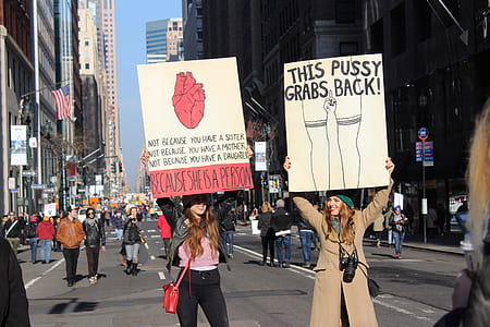 two women holding signboards thumbnail