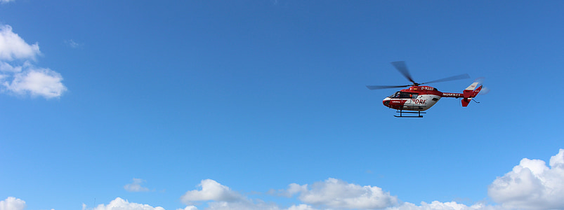 red and white helicopter flying on sky thumbnail