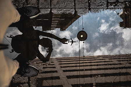 Man Standing on Water Capturing Airplane Reflection thumbnail