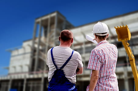 two men standing in front of concrete structure during daytime thumbnail