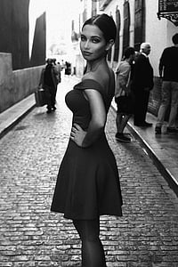 grayscale photo of woman standing near people thumbnail