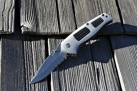pocket knife on brown plank thumbnail