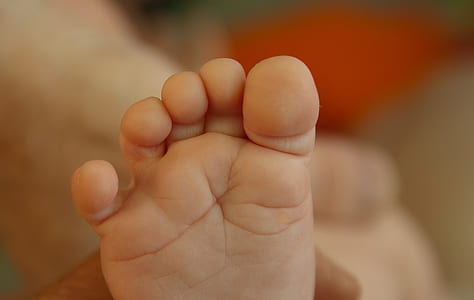 toddler's foot on selective focus photography thumbnail