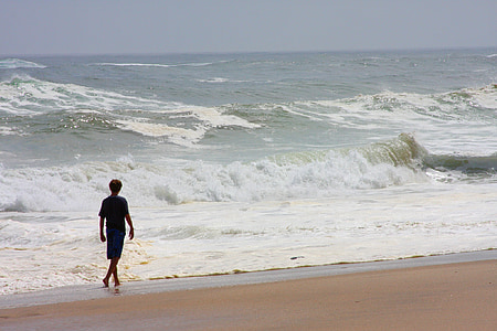 lone person walking on beach line thumbnail