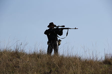 man holding rifle while sighting target thumbnail