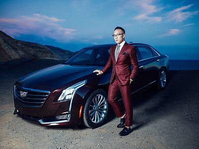 man standing beside brown Cadillac sedan during daytime thumbnail