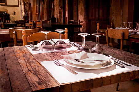 rectangular brown wooden farm table with plates and wine glasses thumbnail