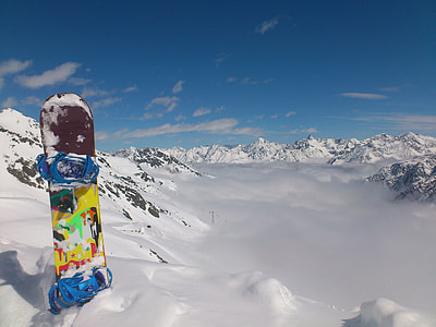 multicolored snowboard on snow during daytime thumbnail