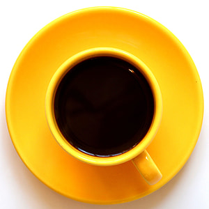 yellow ceramic mug filled with black coffee on saucer thumbnail