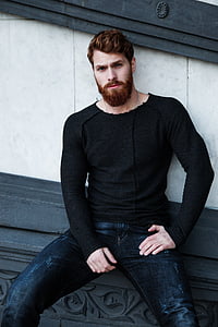 man wearing black long-sleeve shirt leaning on wall thumbnail