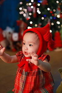 baby girl wearing red hoodie in shallow focus photography thumbnail