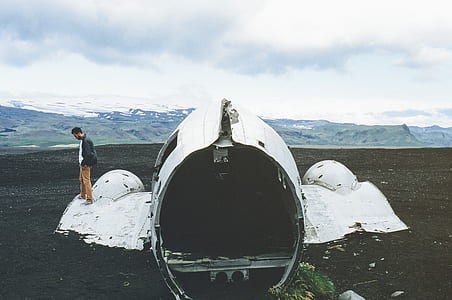 man standing on crashed white airplane during daytime thumbnail