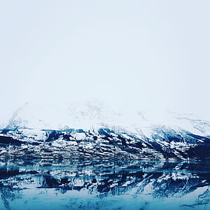 snow covered mountain and body of water thumbnail