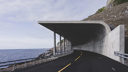 empty road near body of water thumbnail
