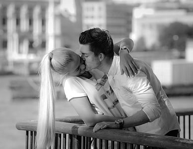 grayscale photography of man kissing woman's cheek thumbnail
