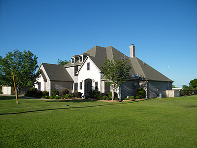 white concrete house with green house field thumbnail
