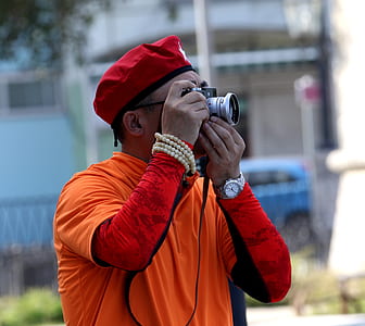 man holding gray and black DSLR camera taking photo thumbnail