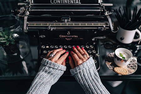 Woman typing on an old typewriter thumbnail