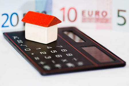 white and red house miniature on top of desk calculator thumbnail