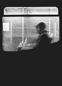 man sitting inside train grayscale photo thumbnail