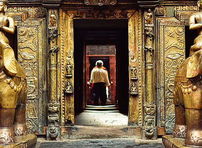 man standing near brass-colored concrete building thumbnail