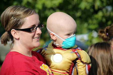 woman carrying child wearing Iron Man costume thumbnail