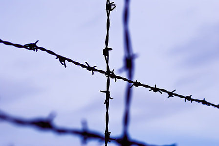 selective focus photography of cross barbed wire during daytime thumbnail