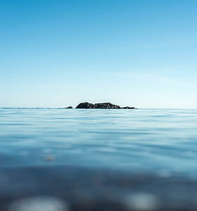 rock formation in the center of body of water thumbnail