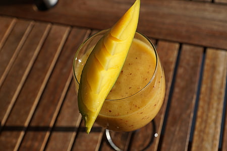 mango shake filled cocktail glass on brown surface thumbnail