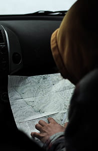person sitting inside vehicle while watching a map thumbnail