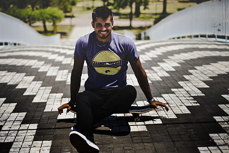 man sitting on skateboard in the middle of road thumbnail