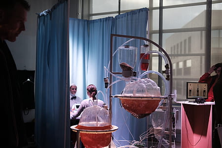 close-up photography of clear apparatus beside woman sitting front of laptop computer thumbnail