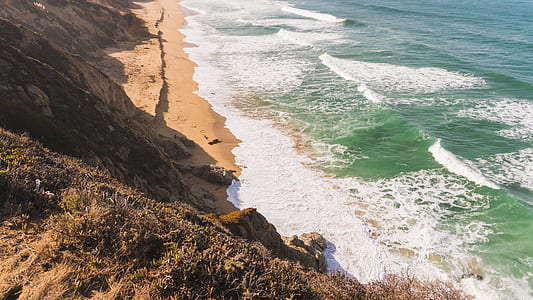 aerial photography of ocean and brown hill thumbnail