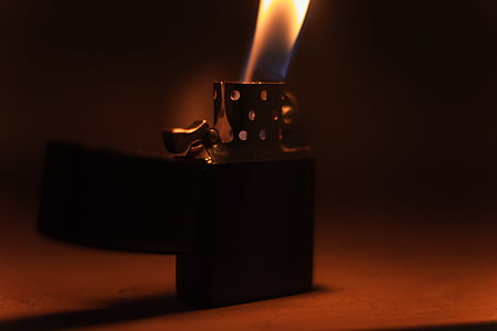 close-up photo of lighted lighter on brown surface thumbnail