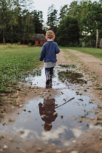 boy in blue sweater walking on pathway during day time thumbnail