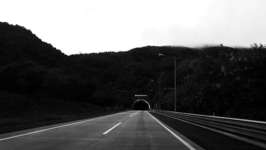 grayscale photo of road towards the tunnel thumbnail