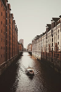 gray and black gondola boat on body of water between high-rise building thumbnail
