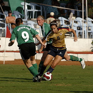 woman kicking ball on field during daytime thumbnail