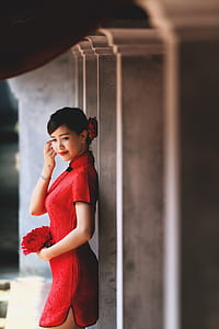 woman wearing cheongsam leaning on grey concrete pillar thumbnail