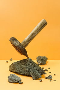 brown wooden handled mallet on stone near yellow wal thumbnail