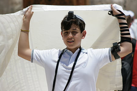 boy wearing white polo shirt holding white blanket at daytime thumbnail