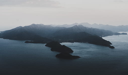 bird's eye photography of calm waters near island thumbnail