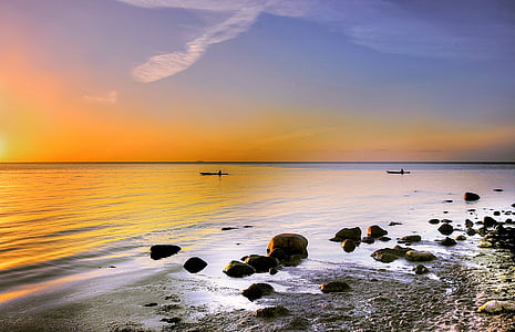 stone and body of water during sunset thumbnail
