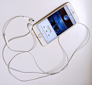turned-on iPhone displaying music on white surface thumbnail