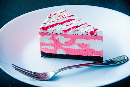 Sliced White and Pink Icing Covered Cake on White Plate With Silver-colored Fork thumbnail