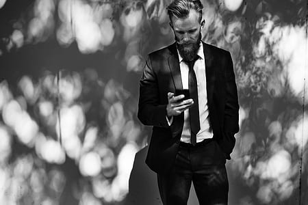 grayscale photography of man using smartphone thumbnail