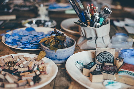 assorted artwork materials on plates and table selective focus photo thumbnail
